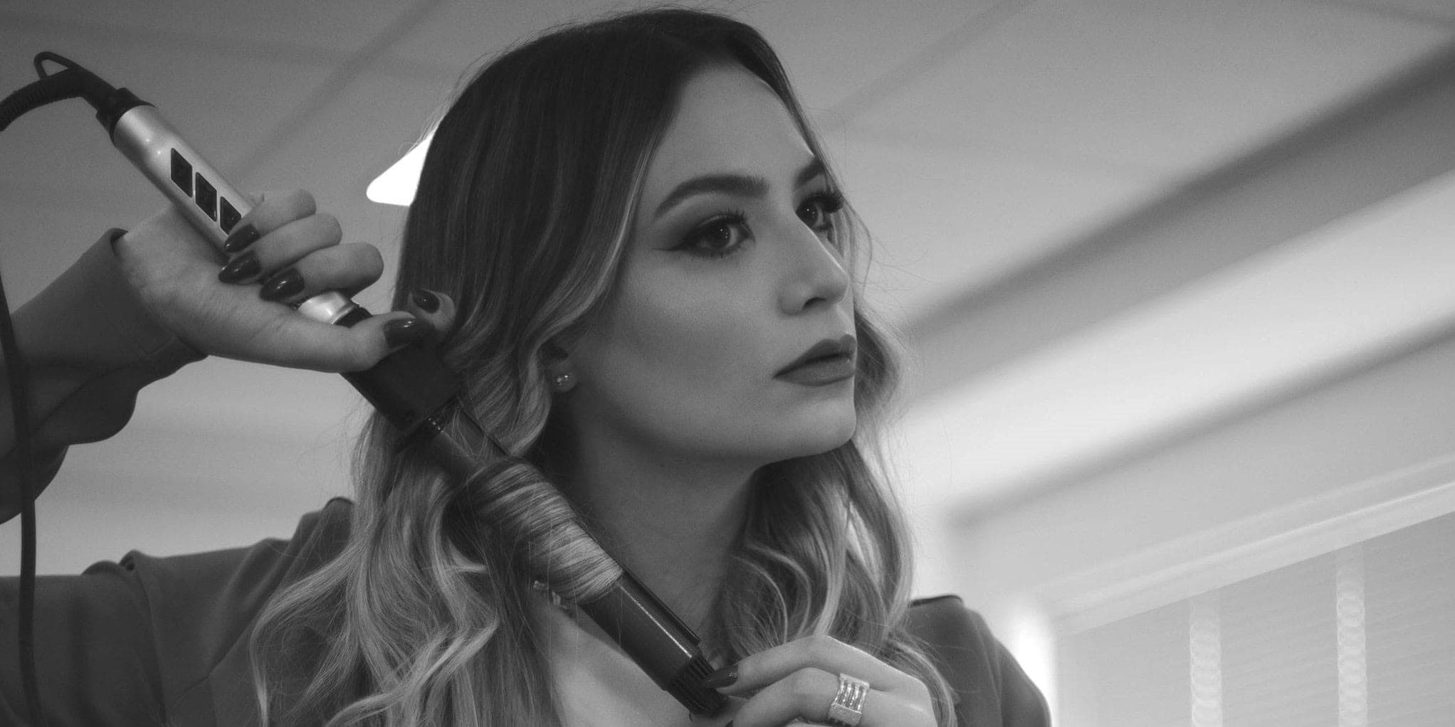 Плойка для завивки волосся - жінка завиває волосся